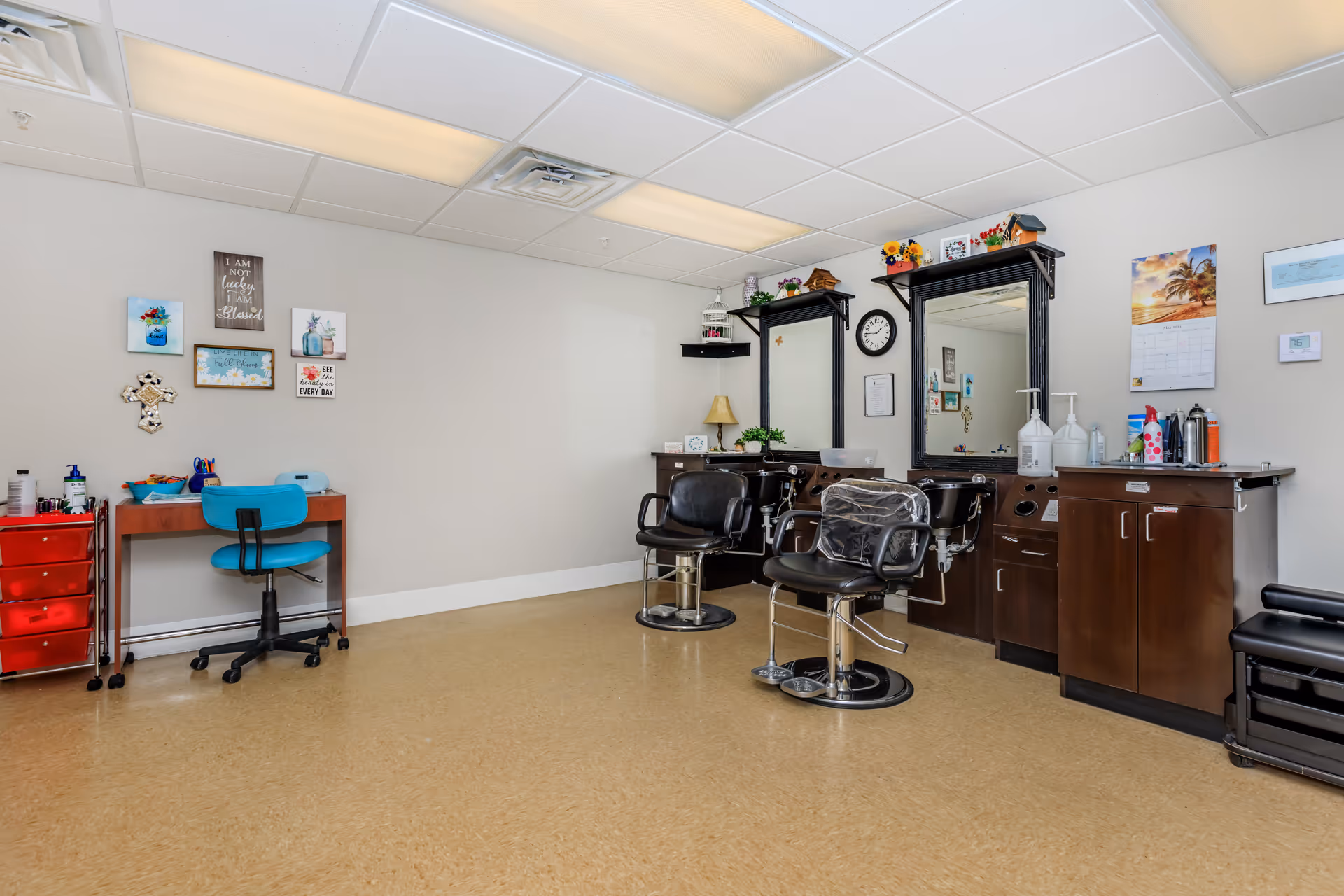 Small salon room with two styling chairs and mirrors, cabinets, and a desk.