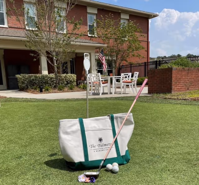Outdoor lawn at Palmettos of Bluffton featuring patio seating and golf equipment.