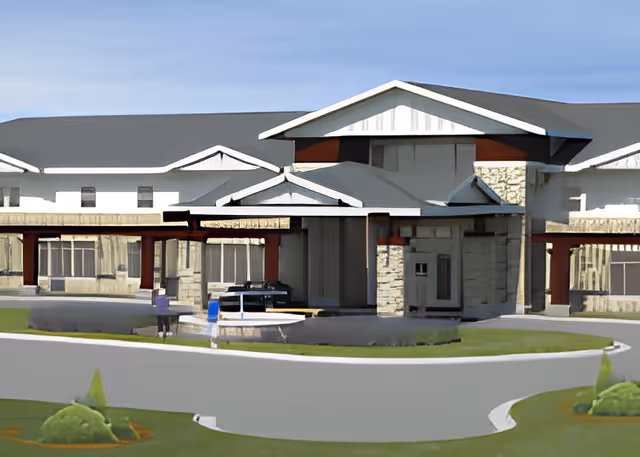 Front entrance of a senior living facility with a covered porte-cochere, circular driveway, and low landscaping.