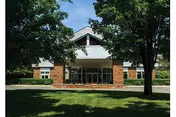 Front view of Wilton Meadows Nursing and Rehabilitation building with trees and a lawn.