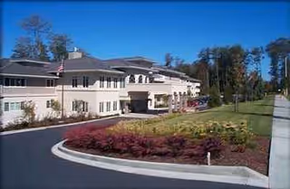 Exterior view of Harbour Pointe Senior Living with a circular driveway and landscaping.