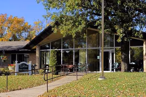 Exterior view of a nursing home with large glass windows and a walkway.