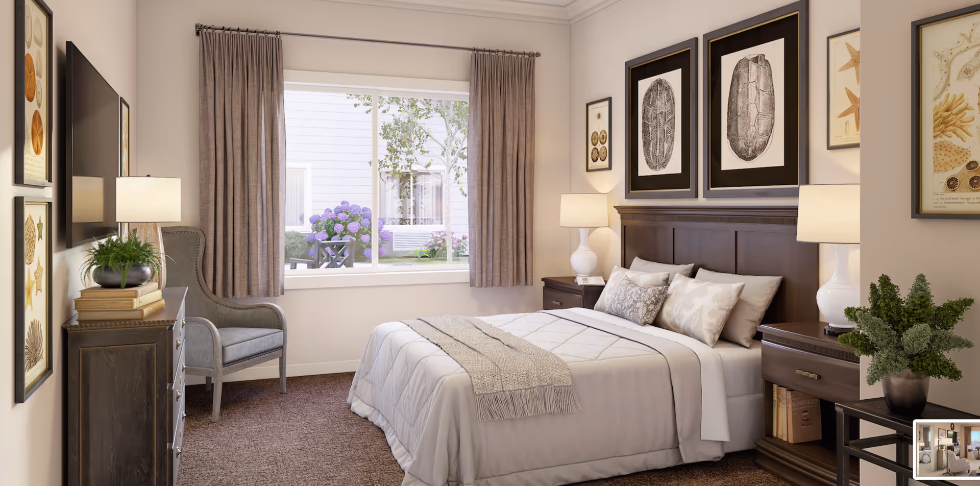 A cozy bedroom in a senior living facility featuring a neatly made bed with white and beige bedding, two bedside tables each with a lamp, framed artwork of shells and turtles on the walls, a gray armchair near a window with beige curtains, a dresser with a potted plant and books, and a view of a garden outside the window.