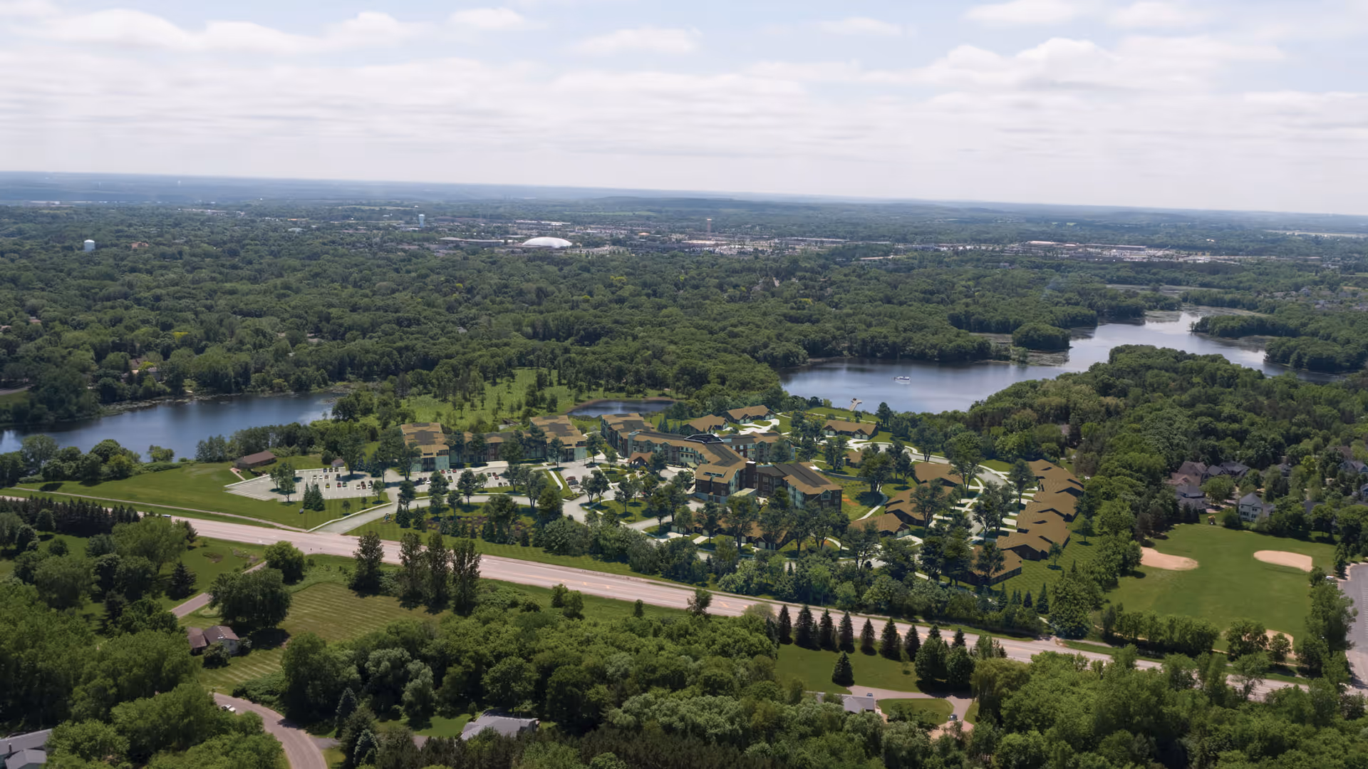 Aerial view of The Lakes at Stillwater campus with multiple buildings surrounded by trees, roads and nearby lakes.