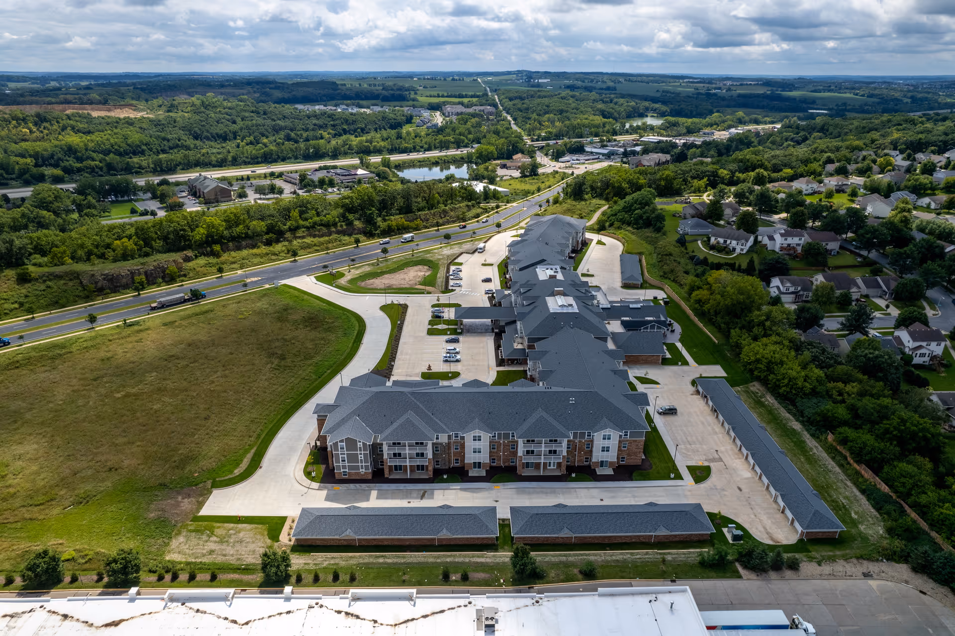Aerial view of the Quarry Ridge Retirement Community campus showing connected buildings, parking areas, roads and surrounding greenery.
