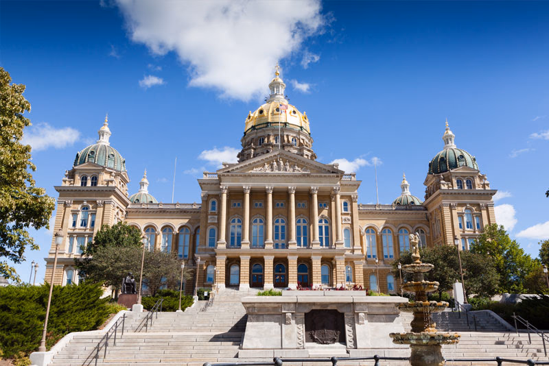Grand neoclassical civic building with domed cupolas and a wide central staircase.