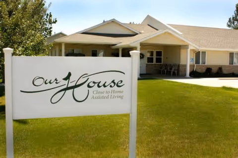 Exterior view of a single-story assisted living building with a front sign.