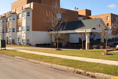 Aster Assisted Living of Clintonville building exterior with entrance canopy and lawn.
