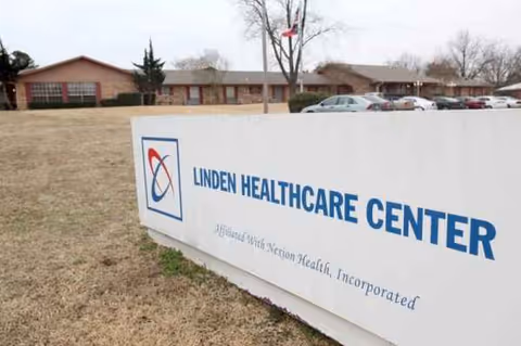 Exterior view of Linden Healthcare Center with a large sign and parked cars.