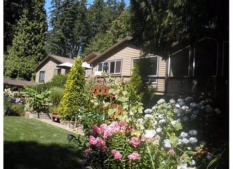 Exterior of Golden Hearth LLC senior living facility with a landscaped garden and blooming hydrangeas.
