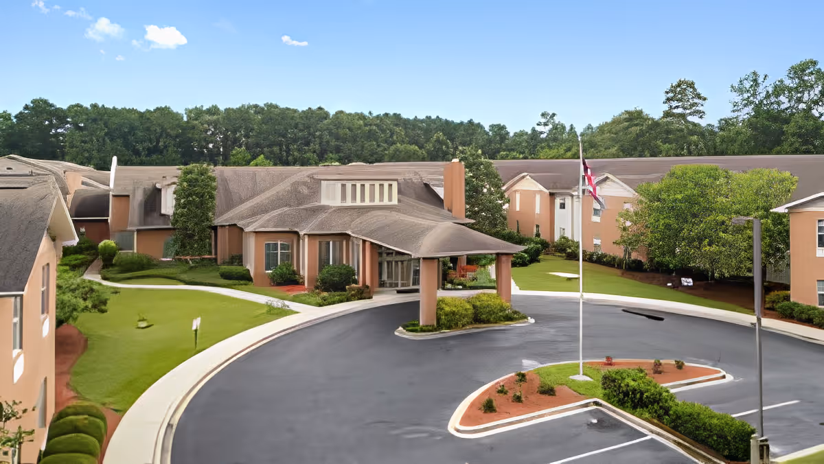 Front exterior of TerraBella Windsor Lake showing a covered entrance, circular driveway, landscaped grounds and a flagpole.