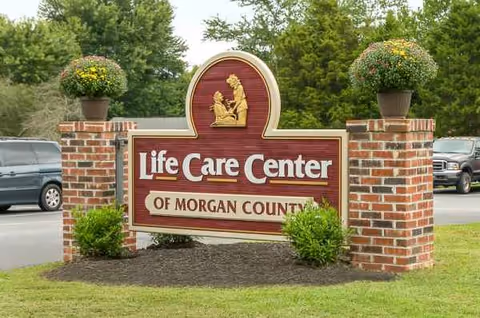 Life Care Center of Morgan County sign at entrance with brick pillars and planters