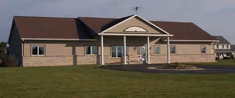Dolphin Manor senior living facility exterior with central covered entrance.