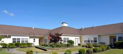 Front view of a single-story senior living facility with manicured landscaping.