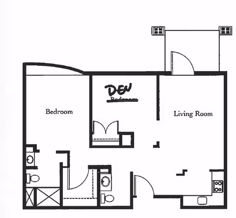 Black and white floor plan of a residential unit showing a bedroom, a den, a living room, a kitchen area, and two bathrooms. The den label is handwritten over the original bedroom label. The layout includes doors and fixtures such as sinks, toilets, and a stove.