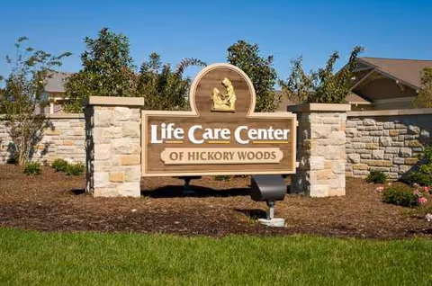 Entrance sign reads Life Care Center of Hickory Woods against stone pillars and manicured landscaping.