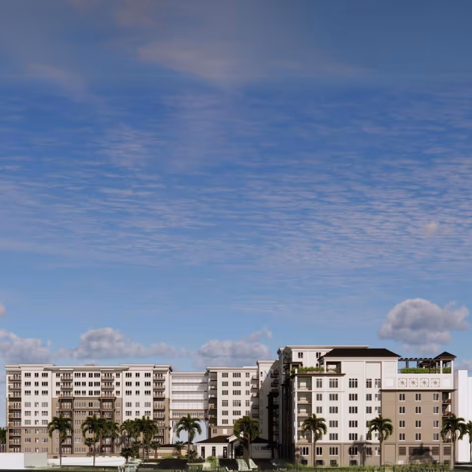 Exterior view of a large multi-story senior living facility building with palm trees in front under a partly cloudy blue sky.