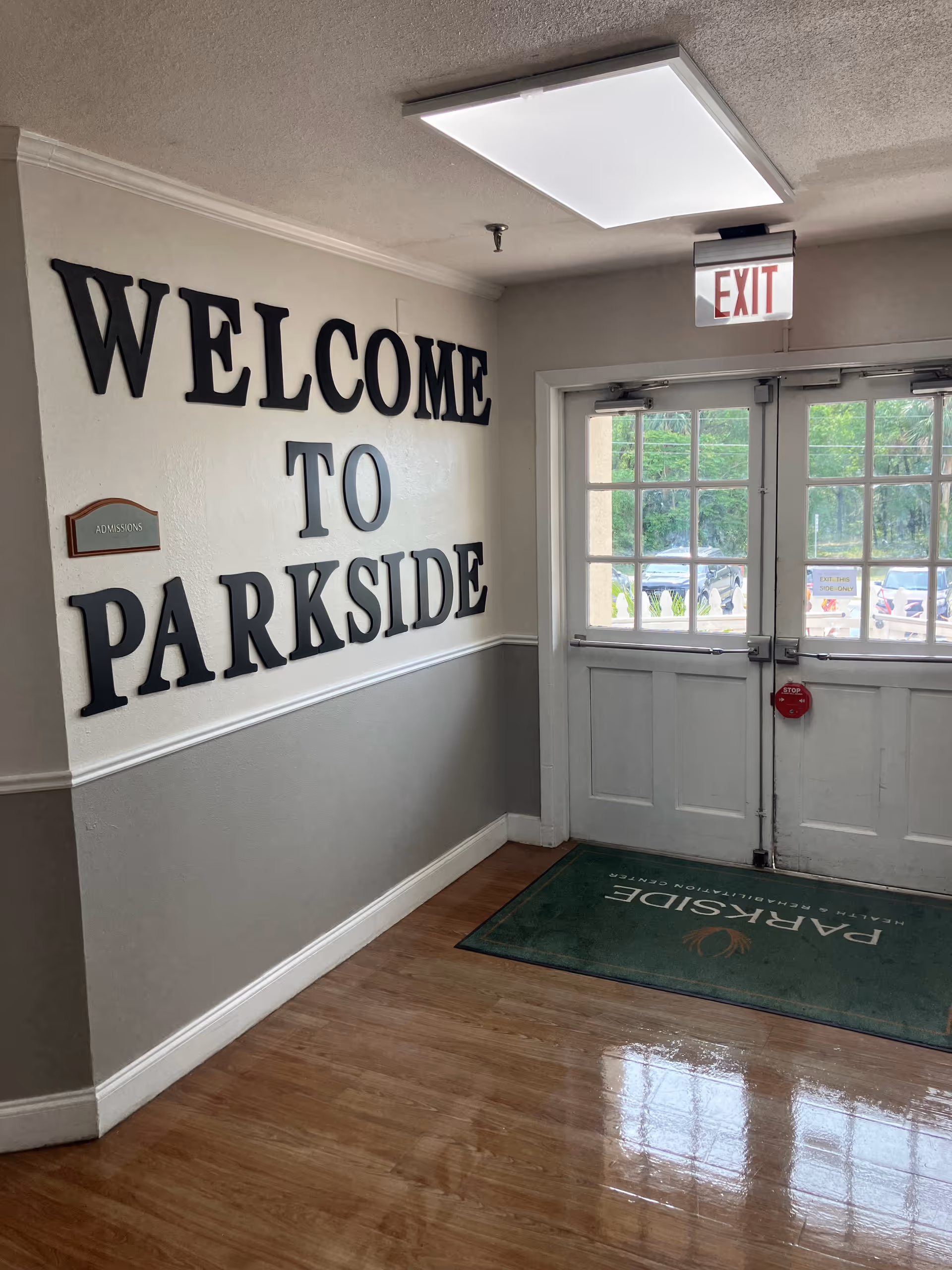 Interior entrance with large 'WELCOME TO PARKSIDE' letters on the wall, double exit doors and a green Parkside floor mat.