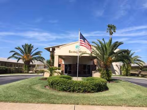 Sandalwood Rehabilitation and Nursing Center entrance with a circular driveway and palm trees.