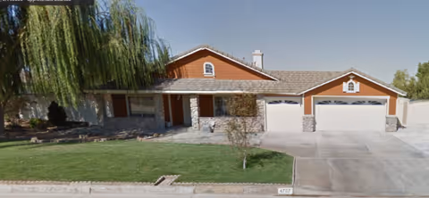 Front exterior of a single-story residential care facility with a two-car garage.