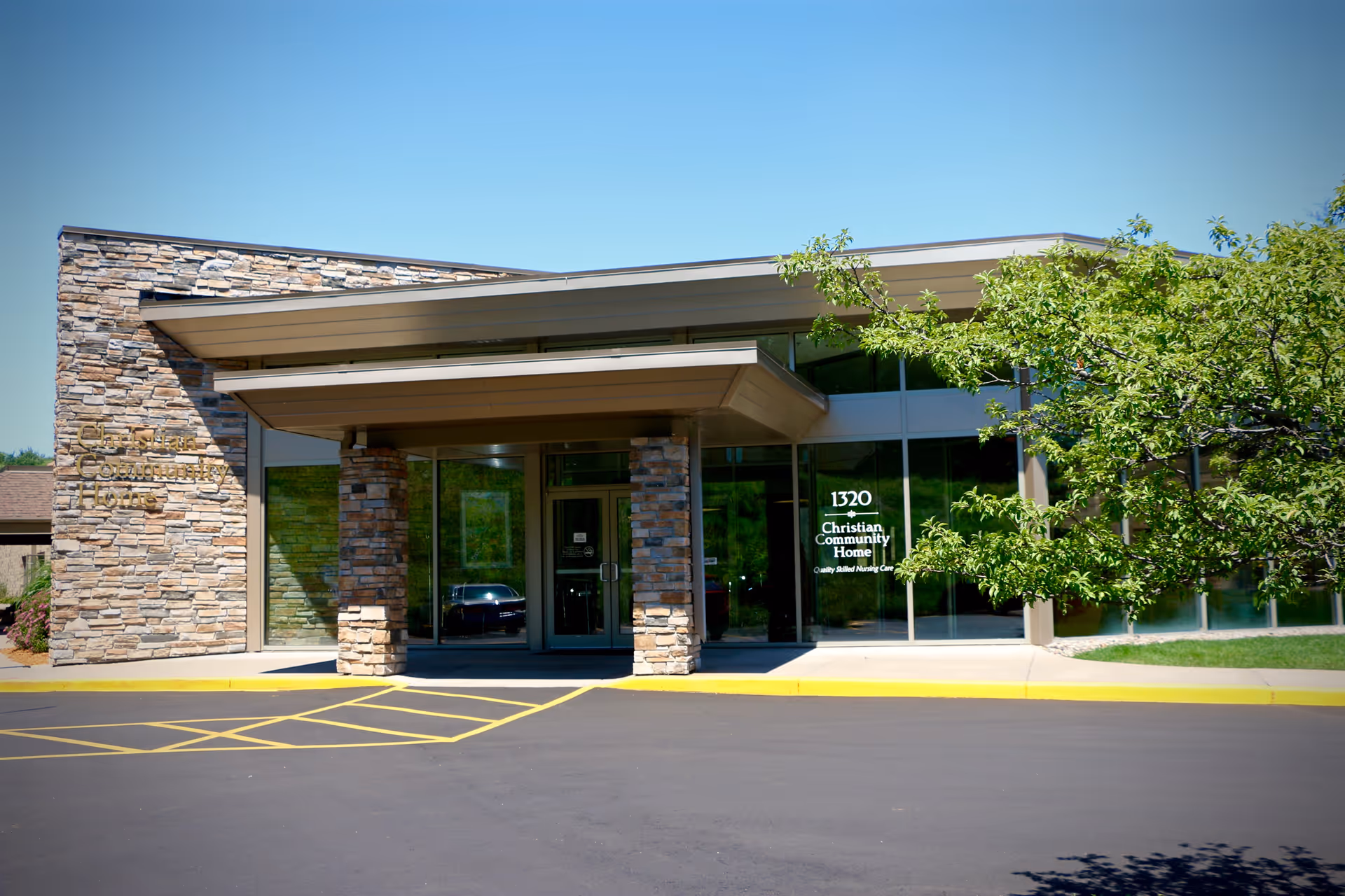 Front entrance of the Christian Community Home building with stone pillars, glass doors, and the address number 1320 visible.