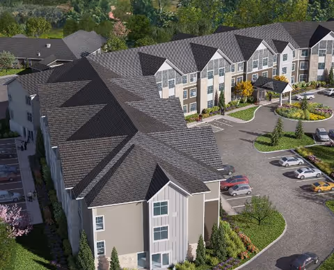 Aerial view of a senior living campus with interconnected buildings, parking, and landscaped grounds.