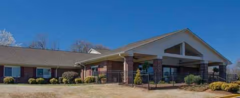 Front view of a single-story brick senior living facility with a covered entrance.