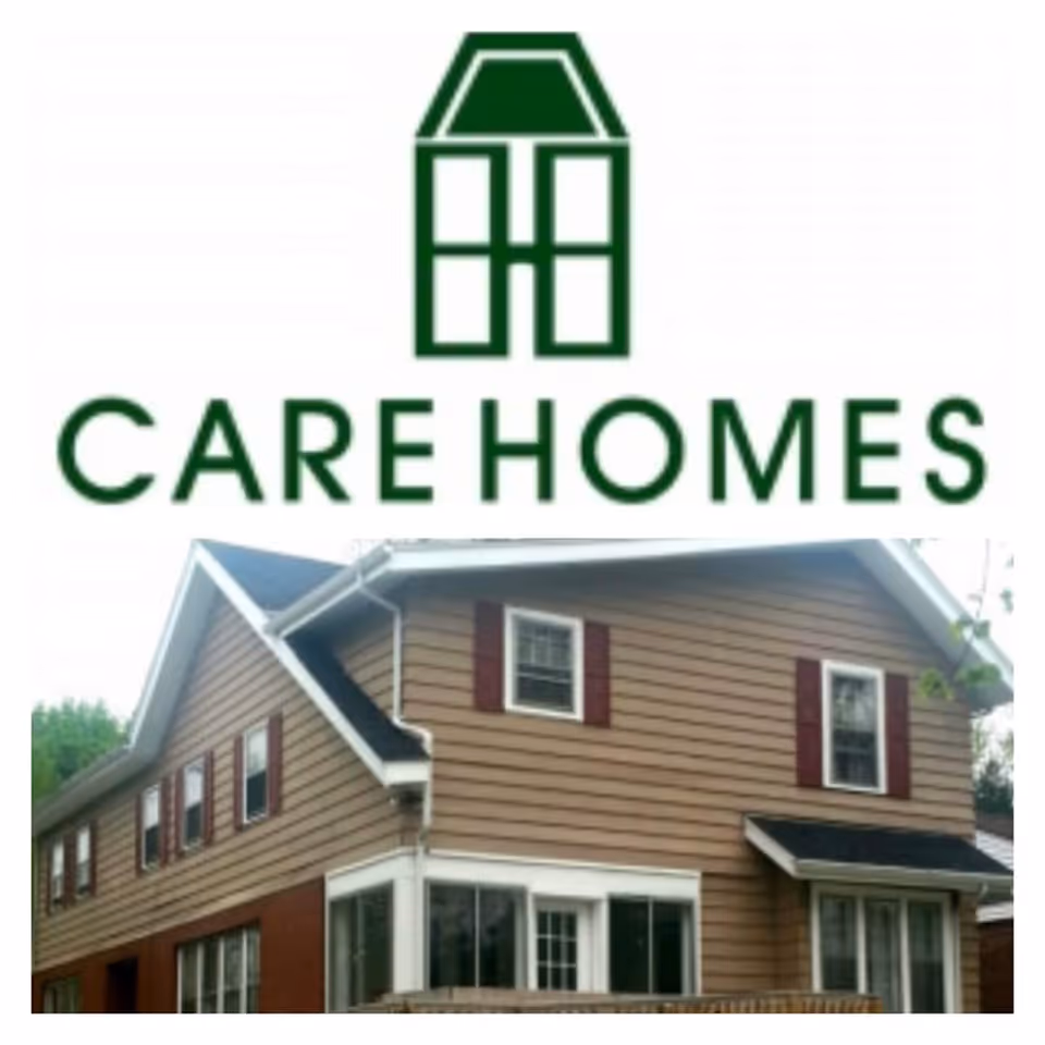 A green 'CARE HOMES' logo above a photo of a two-story beige-brown house with white trim and red shutters.