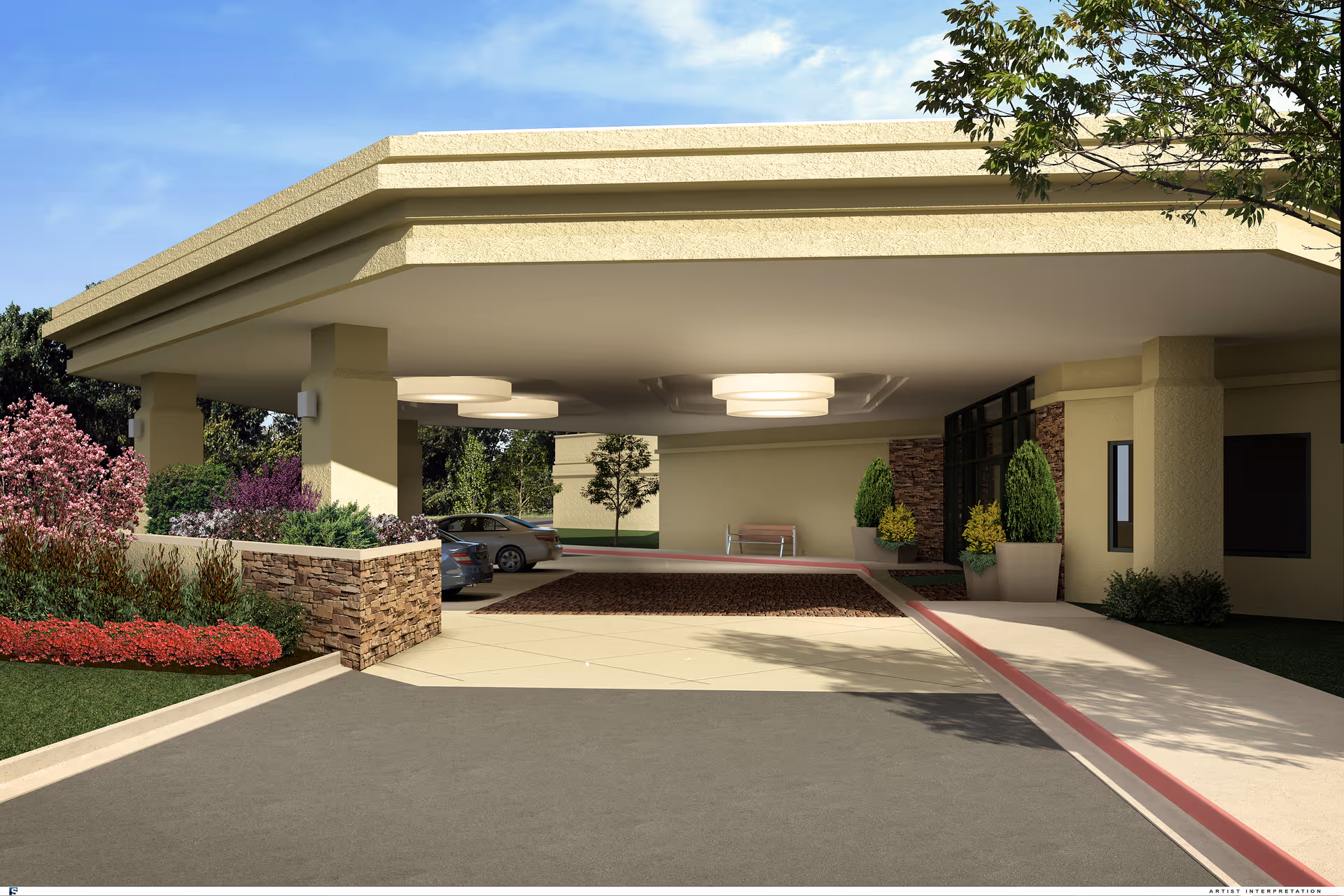 Covered driveway entrance of a building with beige walls and stone accents, featuring landscaped flower beds with red and pink flowers, two parked cars, and a bench near the entrance under a large overhang with ceiling lights.
