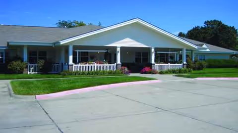 Exterior of Homestead House, a single-story senior living facility with covered porch and manicured lawn.
