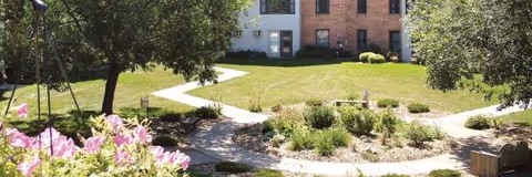 Front exterior of Benet Place with lawn, walkway, and landscaped garden.