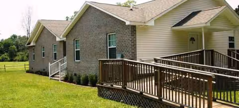 Exterior view of New Beginnings Residential Care Facility with a ramped entrance and manicured lawn
