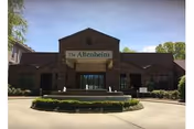 Front view of The Altenheim facility with circular driveway and landscaping.