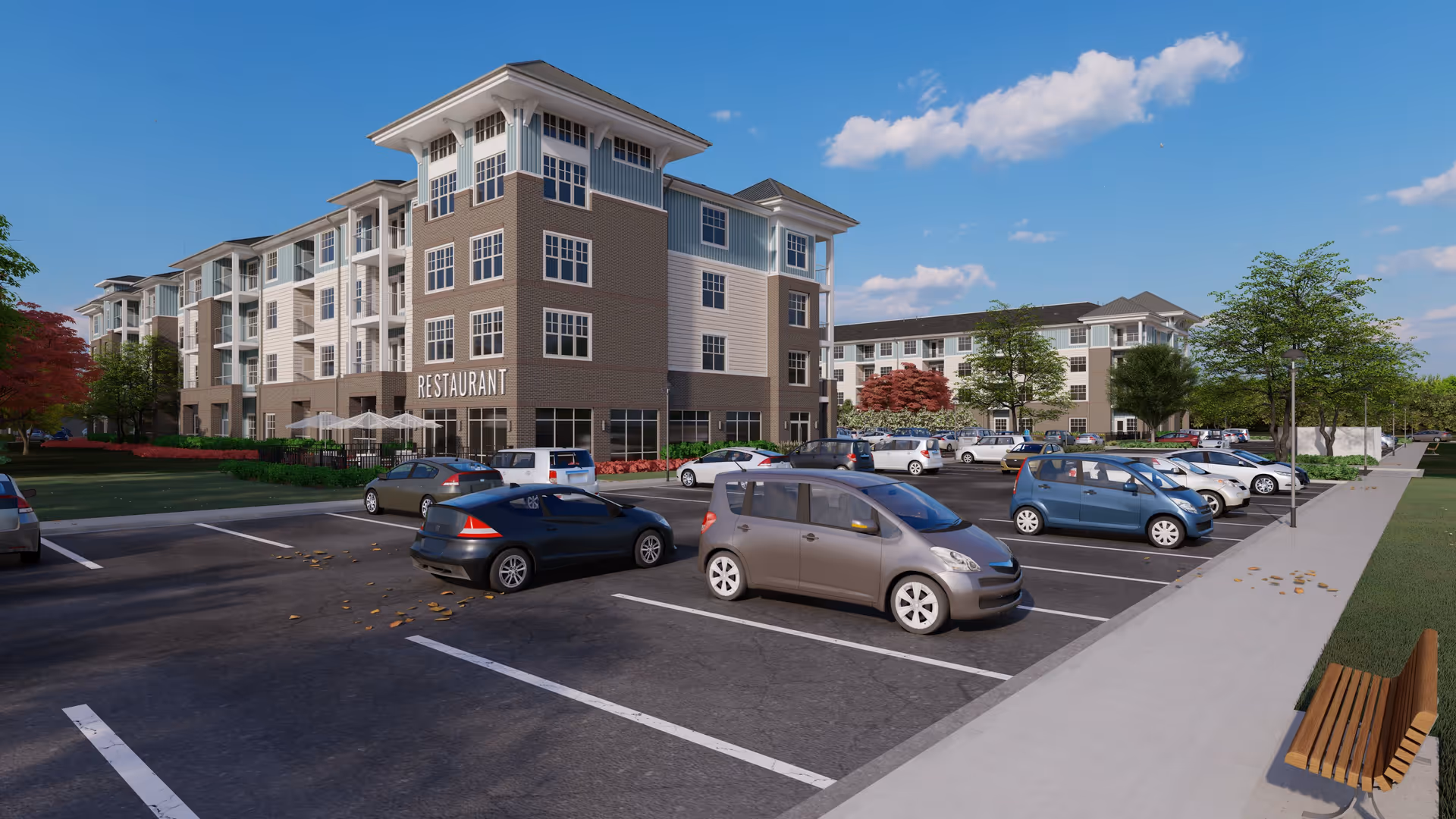 Exterior view of a multi-story senior living facility building with a restaurant on the ground floor. The building is surrounded by a parking lot with several parked cars, trees, and a sidewalk with a bench. The sky is clear with a few clouds.