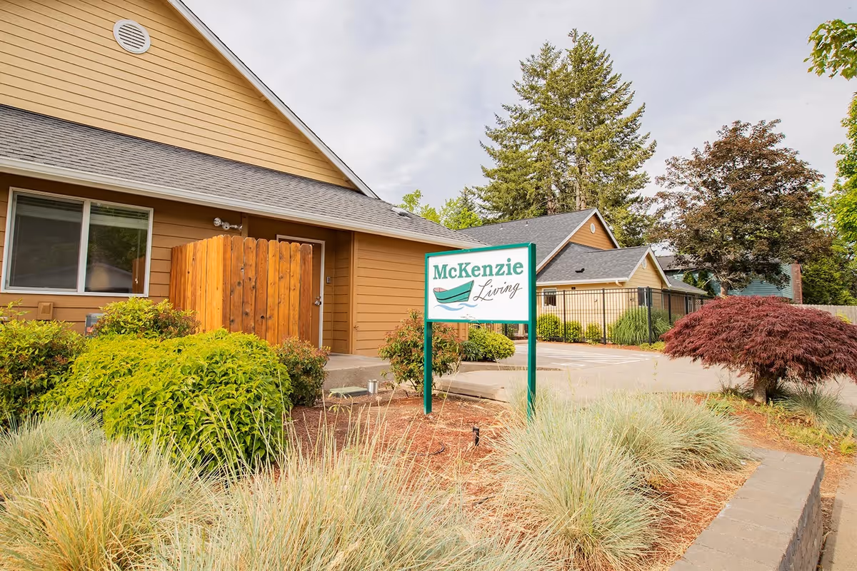 Exterior view of McKenzie Living Springfield with landscaped gardens and a sign.