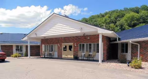 Exterior view of Elkader Care Center entrance with brick facade and covered drop-off area.