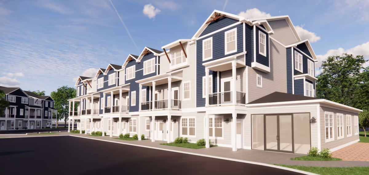 Exterior view of a modern multi-story residential building with blue and white siding, multiple balconies, and large windows under a clear blue sky.