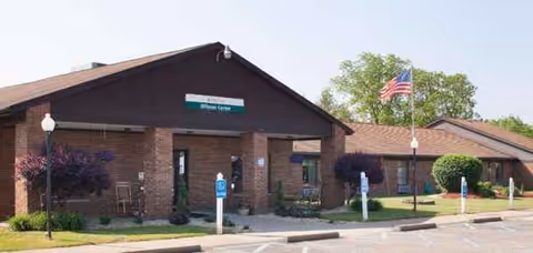 Exterior view of Willows Center building with parking and American flag.
