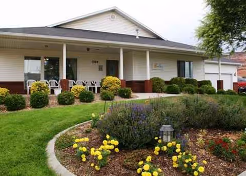 Single-story Beehive Homes facility with a front porch and landscaped garden.