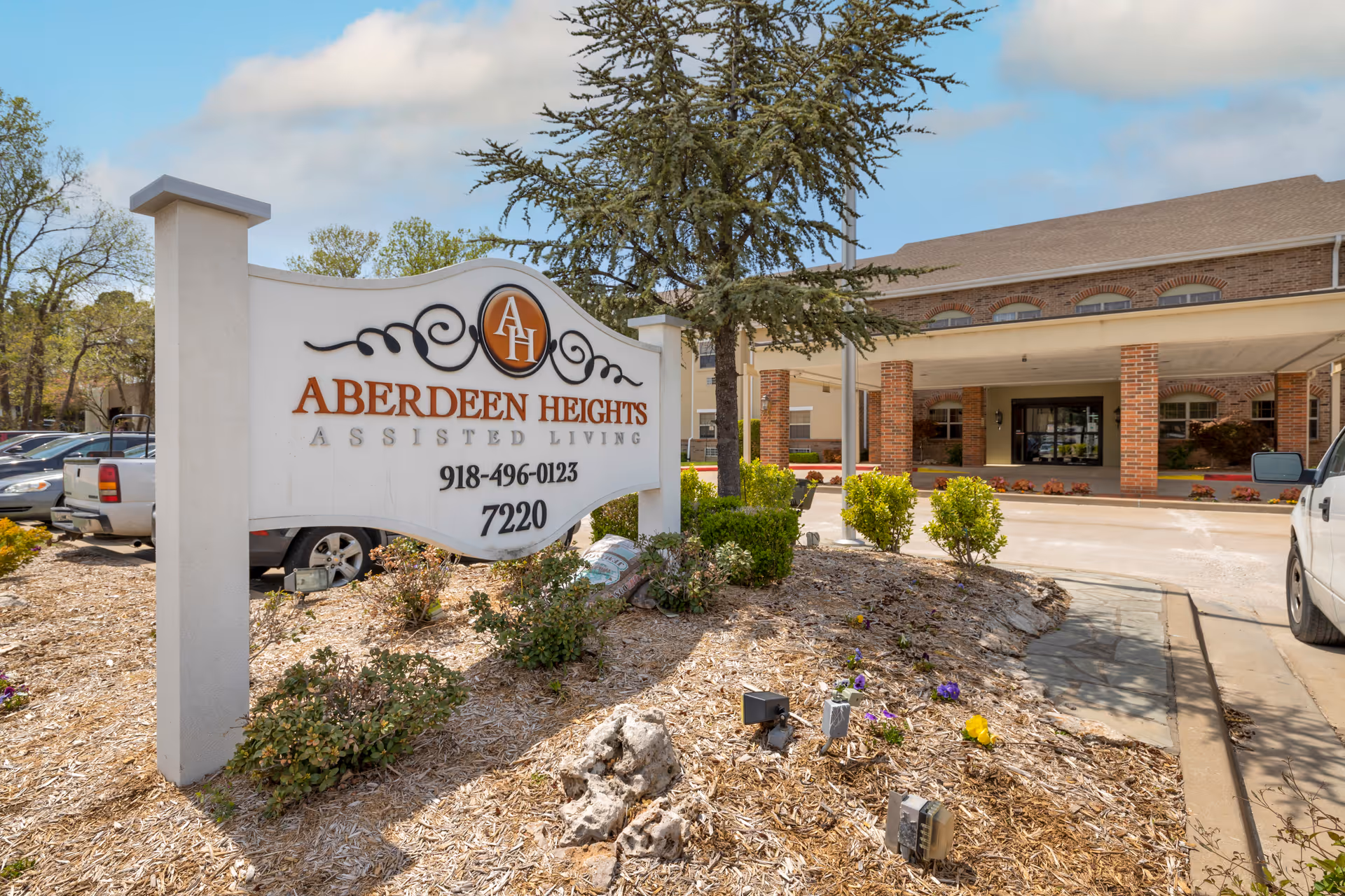 Front entrance and landscaping with a large sign reading "Aberdeen Heights Assisted Living" in front of the facility.