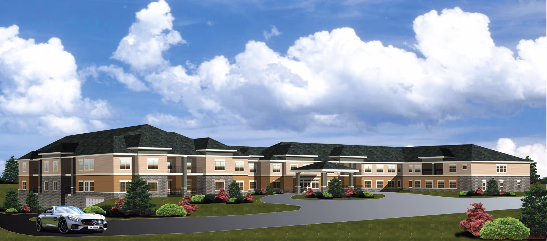 Exterior view of a large, two-story senior living facility building with beige and brown walls, dark roof, and multiple windows. The building is surrounded by landscaped greenery, including bushes and small trees, under a partly cloudy blue sky. A silver sports car is parked on the driveway in front of the building.