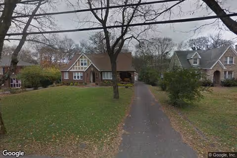 Exterior view of Bay View Gardens campus with cottage-style buildings and lawns.
