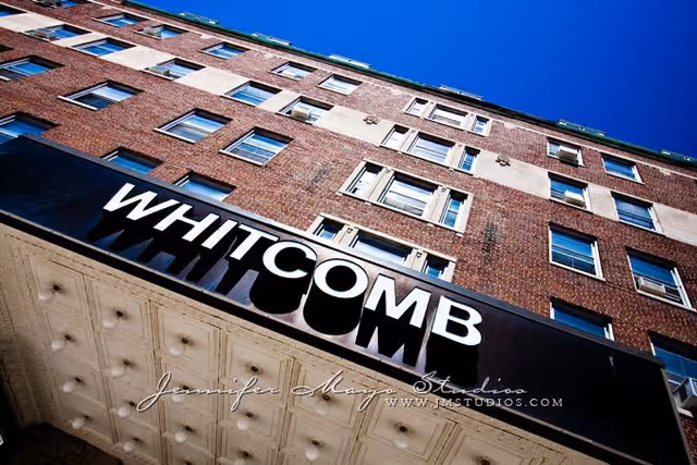 Low-angle view of the Whitcomb building facade and marquee sign against a blue sky.