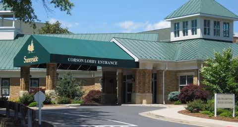 Sunnyside senior living facility entrance with green awning and brick exterior