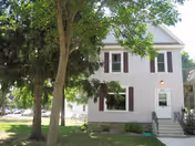 Front exterior of Gerard Hall with doorway, steps, windows, and surrounding trees.