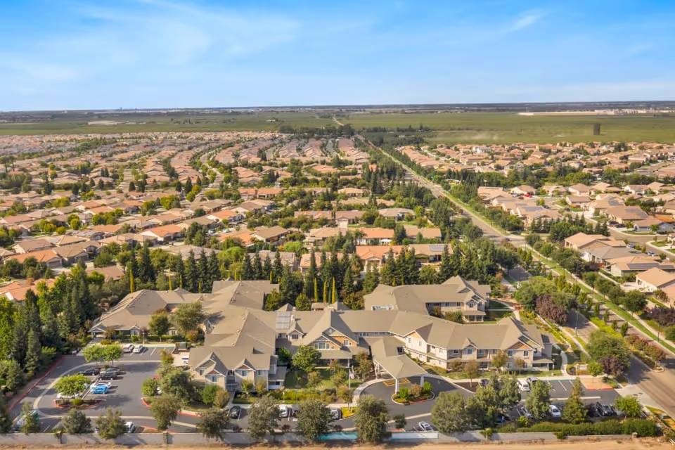 Aerial view of The Commons at Union Ranch senior living complex surrounded by a suburban neighborhood and streets.