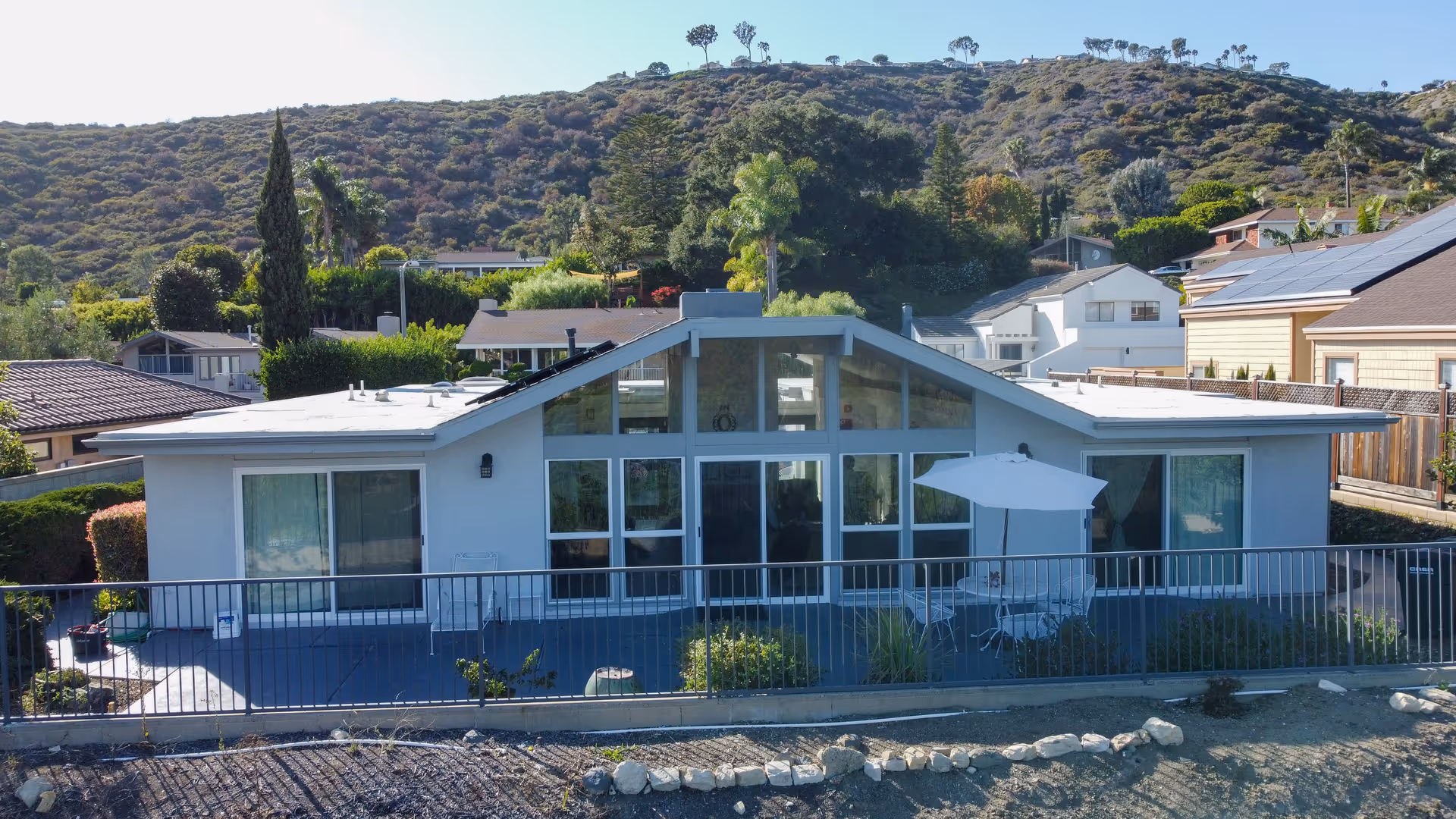 A single-story modern senior living building with large glass windows and a patio.