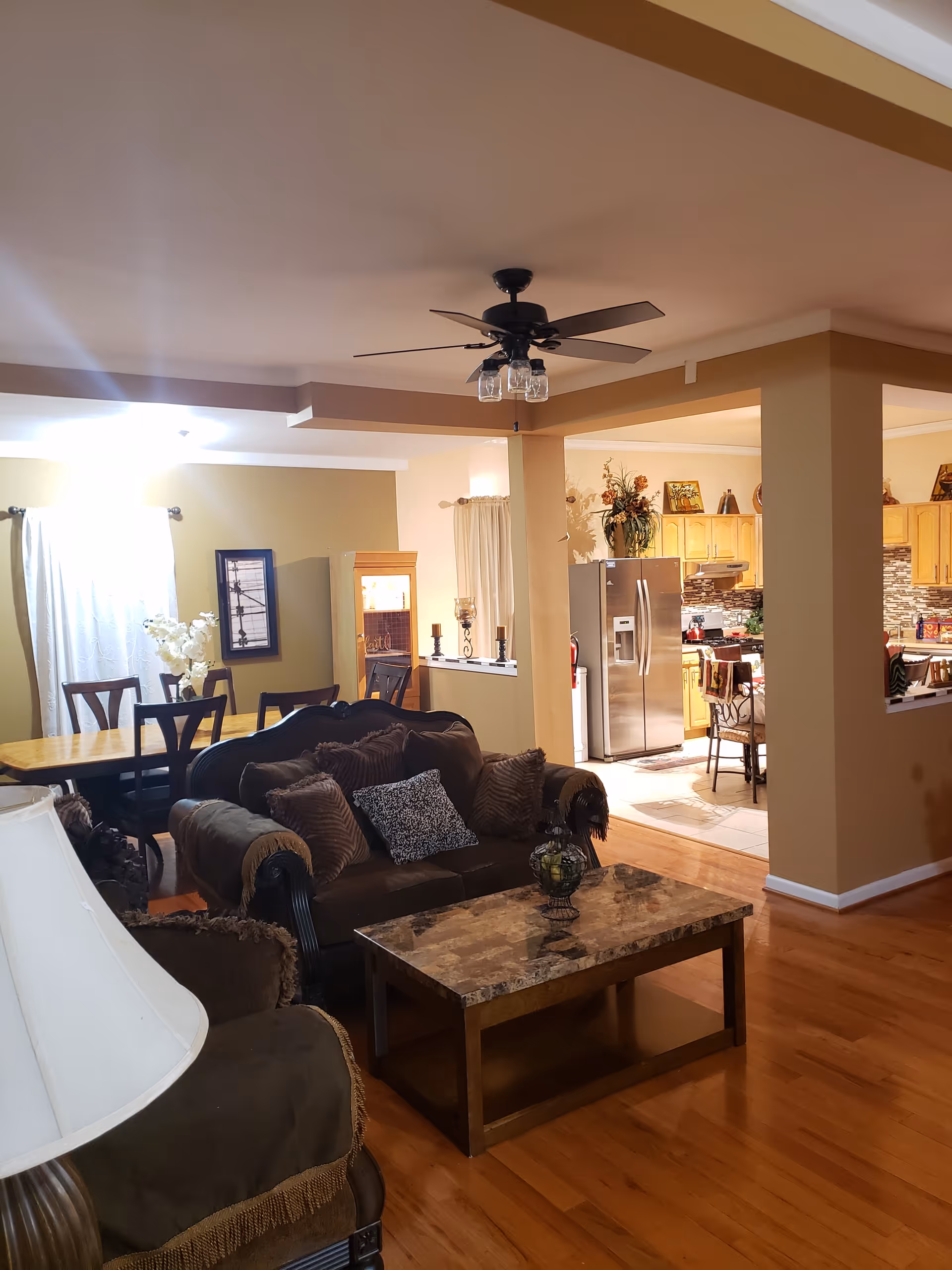 Open-plan living room with a sofa, coffee table, dining table and a view into the kitchen area.