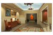 A spacious, well-lit hallway in a senior living facility with a decorative ceiling light fixture, framed artwork on the walls, a wooden sideboard with a lamp and decorative items, and a patterned carpet on the floor.