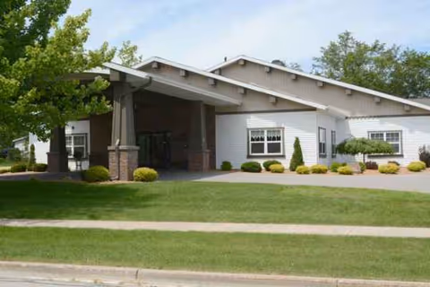 Exterior view of The Brook of Grayling facility with landscaped entrance and driveway